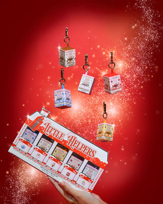 Set of 'Little Helpers' keychain lip balms on a red background