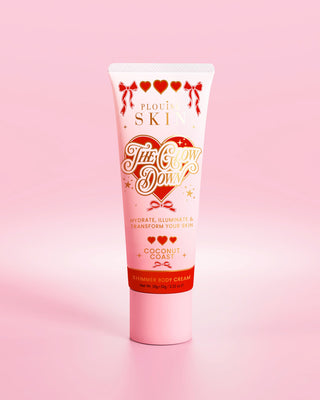 पी.लुईस द ग्लो डाउन की गुलाबी ट्यूब, गुलाबी पृष्ठभूमि पर नारियल के तट की सुगंध में चमकती बॉडी क्रीम
