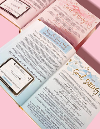 An inspirational diary laid out with multiple pages visible, showing sections on goal setting and other developmental topics, with a pink background.